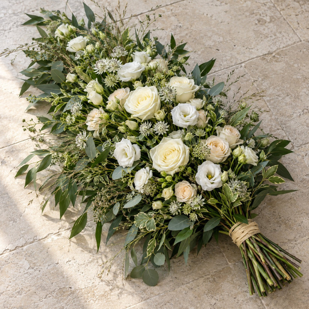 Clairière, gerbe de deuil liée à la main, format Généreux (L. 80 cm) : roses blanches, lisianthus, astrance et feuillages longs